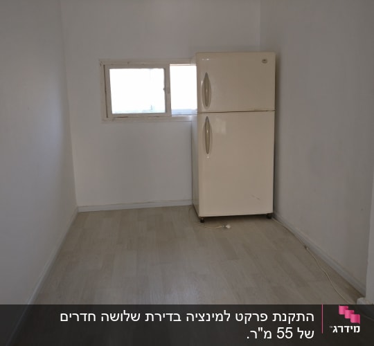 חדר עם רצפת פרקט בהירה ומקרר לבן